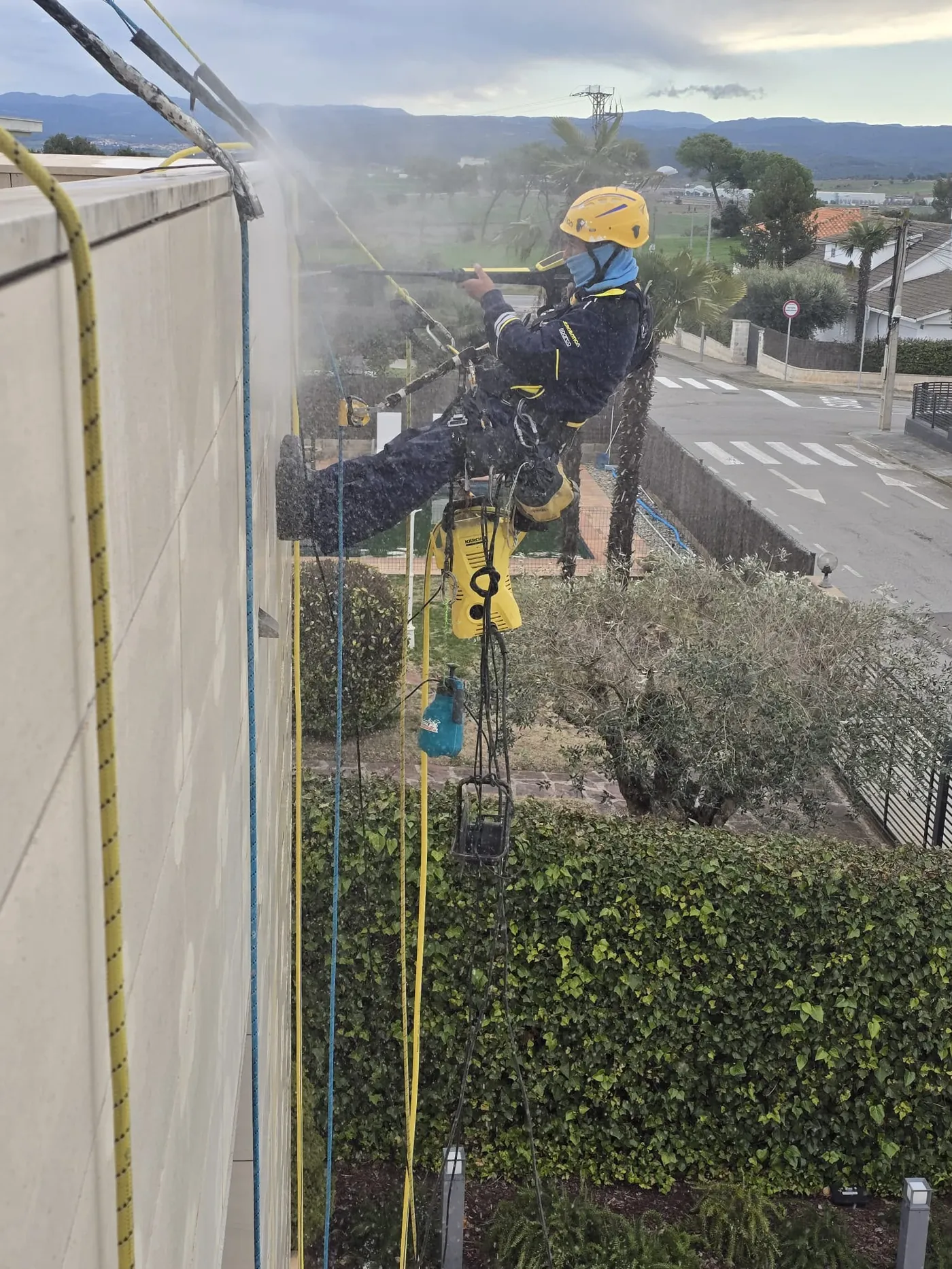 Técnico de Solutions Vertical reparando una fachada por acceso con cuerdas