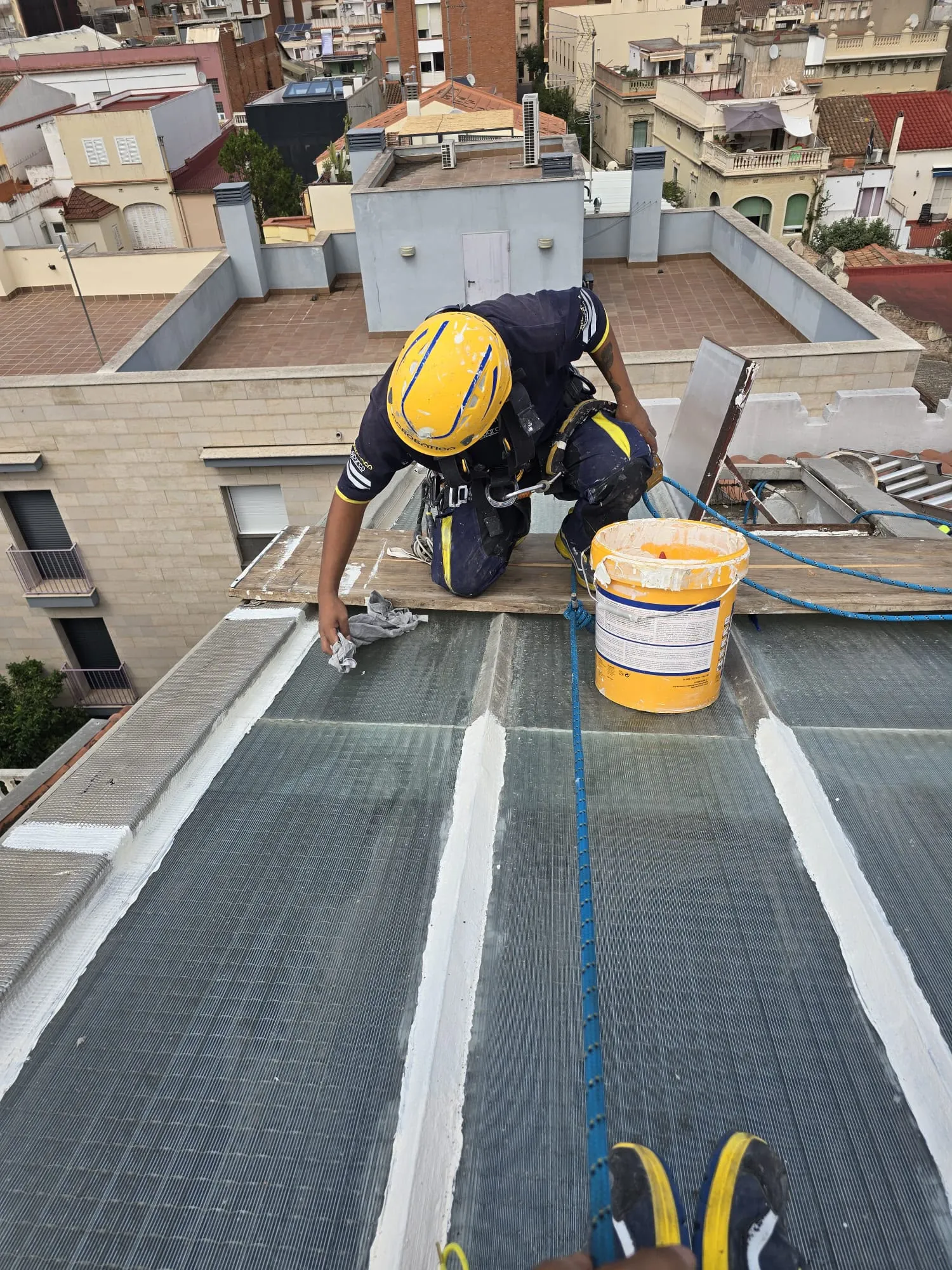 Técnico instalando la unidad exterior de un aire acondicionado en fachada por acceso por cuerdas